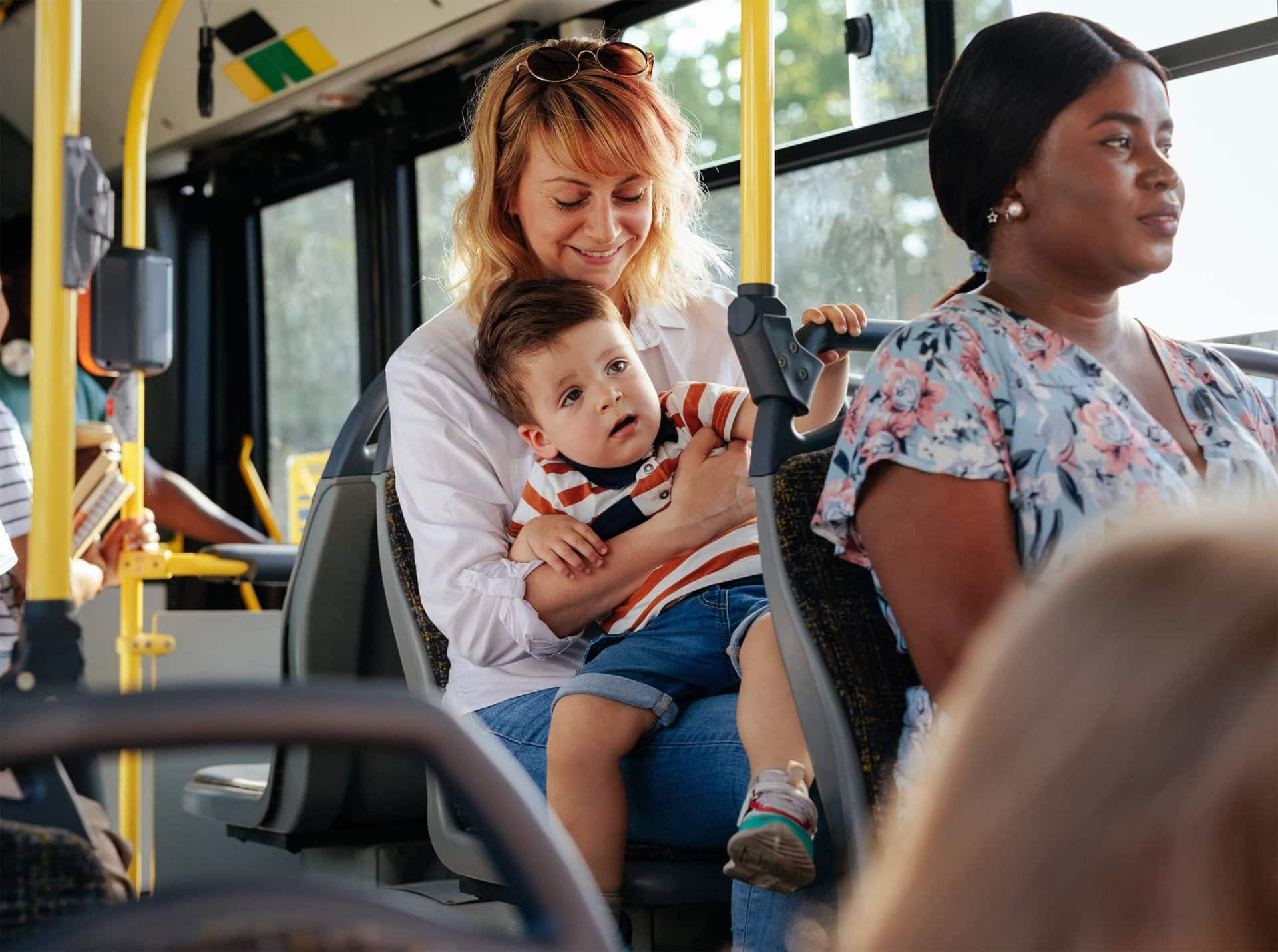 2 women and child riding the bus to the mall