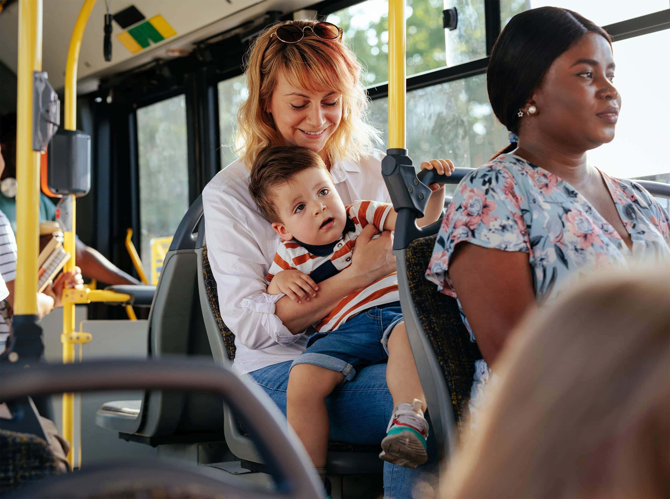 2 women and child riding the bus to the mall